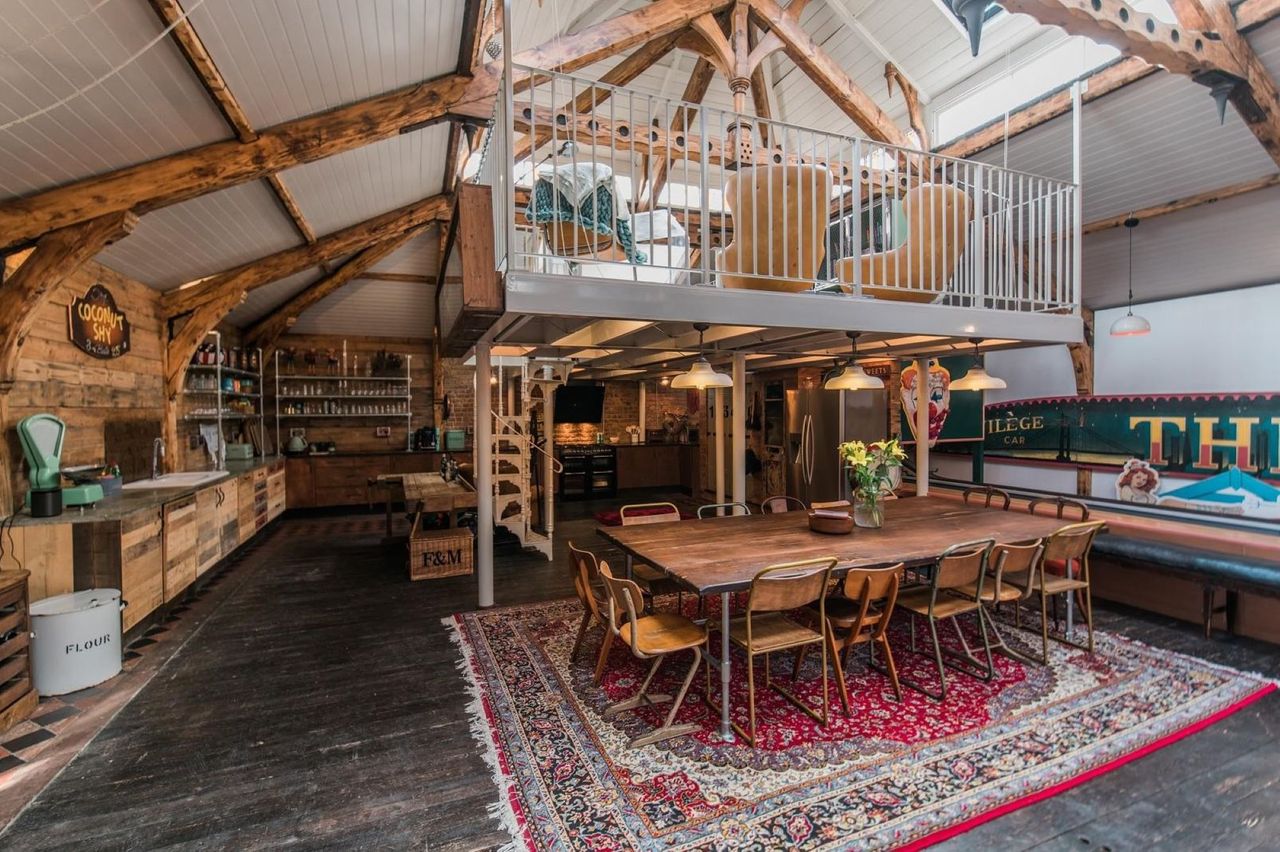 A kitchen-diner with a wooden dining table and a kitchen island all with oak tops