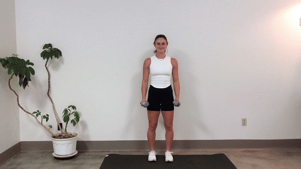 trainer Kirra Mitlo doing a dumbbell hammer curl to lateral raise