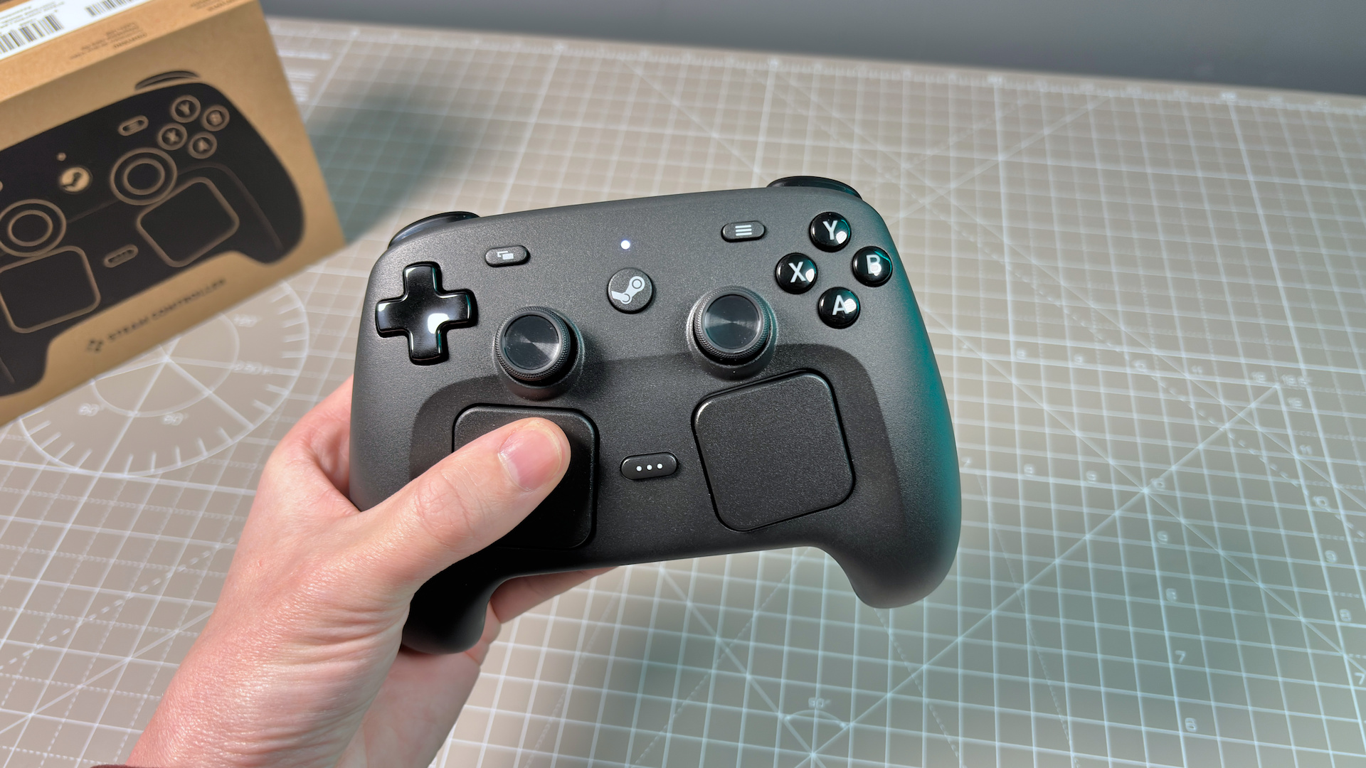 The Steam Controller on a desk during a teardown, with various parts removed.