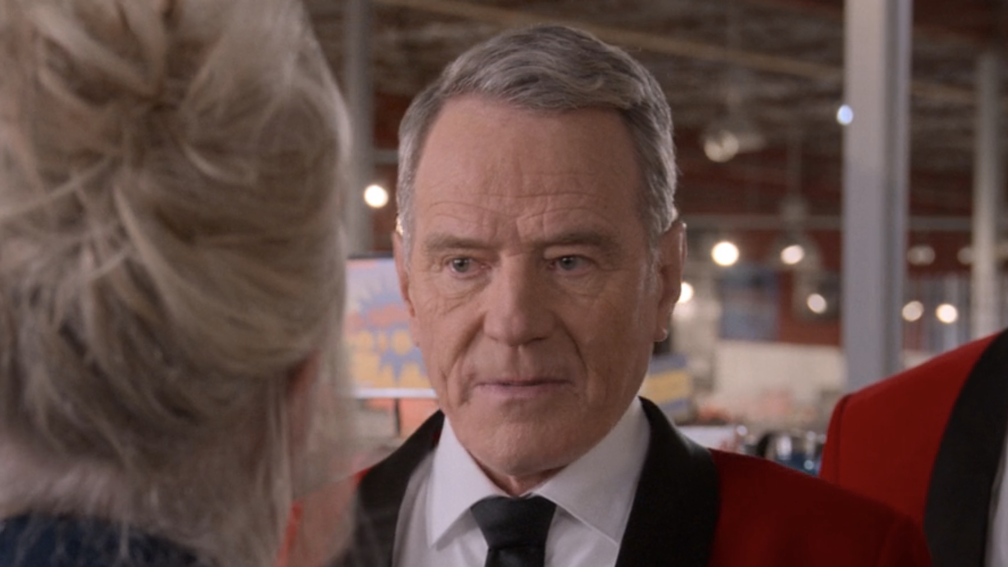 Bryan Cranston wearing a red blazer in Life's Still Unfair.