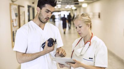Male and female nurses reviewing document
