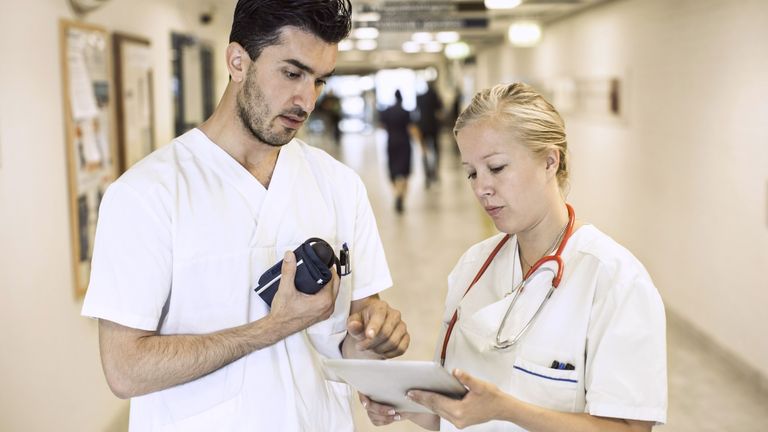 Male and female nurses reviewing document