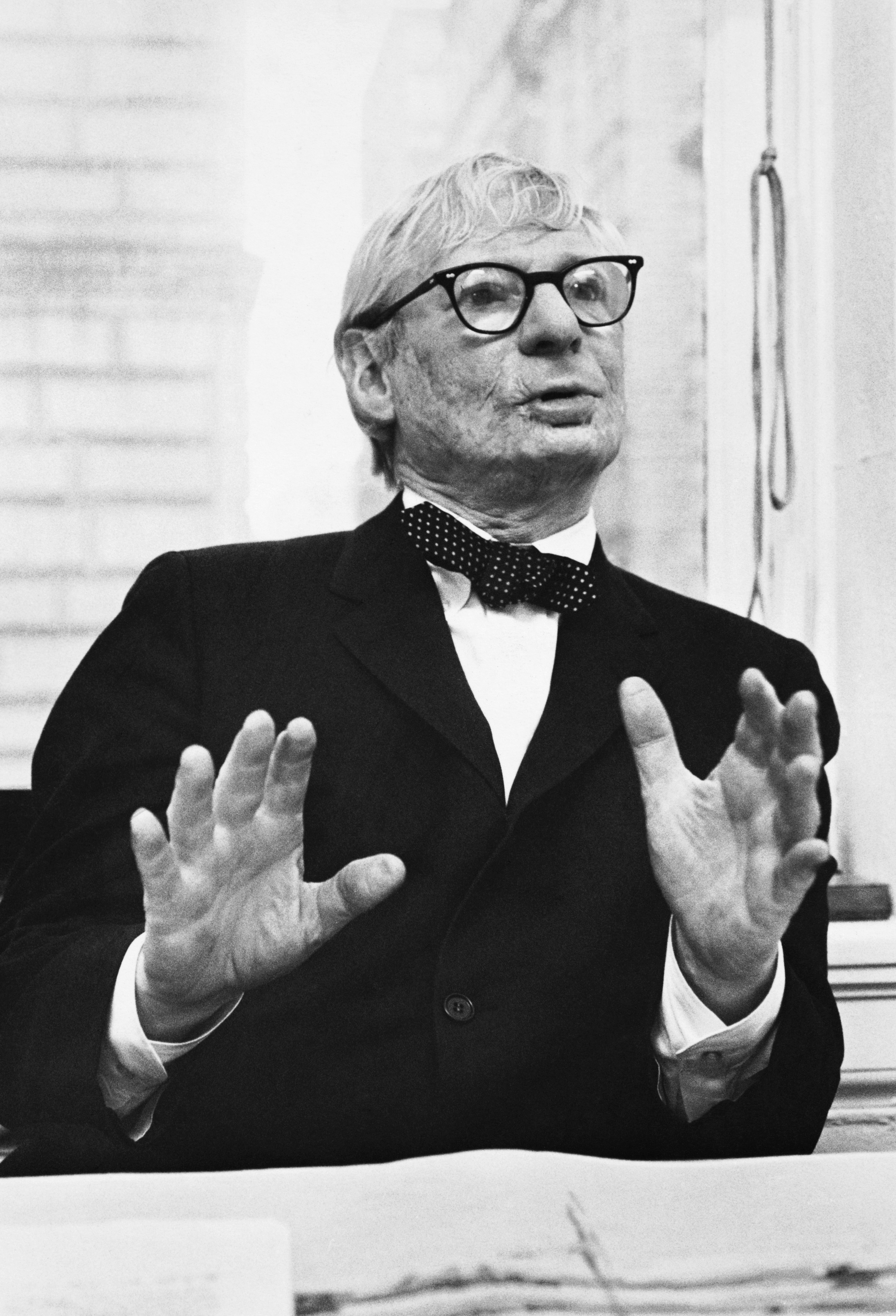 black and white photo of architect Louis Kahn, caught while talking and gesturing