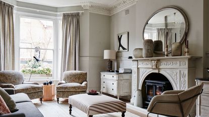 Room with original period features, bay window, sash window, armchairs, sofa, wood burning stove