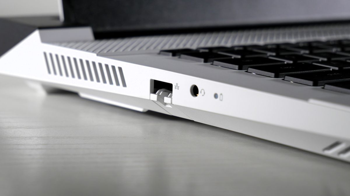 Dell G16 (7630) open on a white table, highlighting the ports on the left side, including Ethernet and headphone jack.