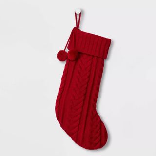 red knitted Christmas stocking with pom poms