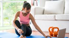 Woman begins kettlebell workout at home