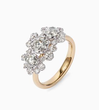 Gold engagement ring with diamonds of different sizes clustered together