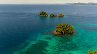 Cordillera de Coiba of Panama, tiny tropical islands amidst blue ocean.