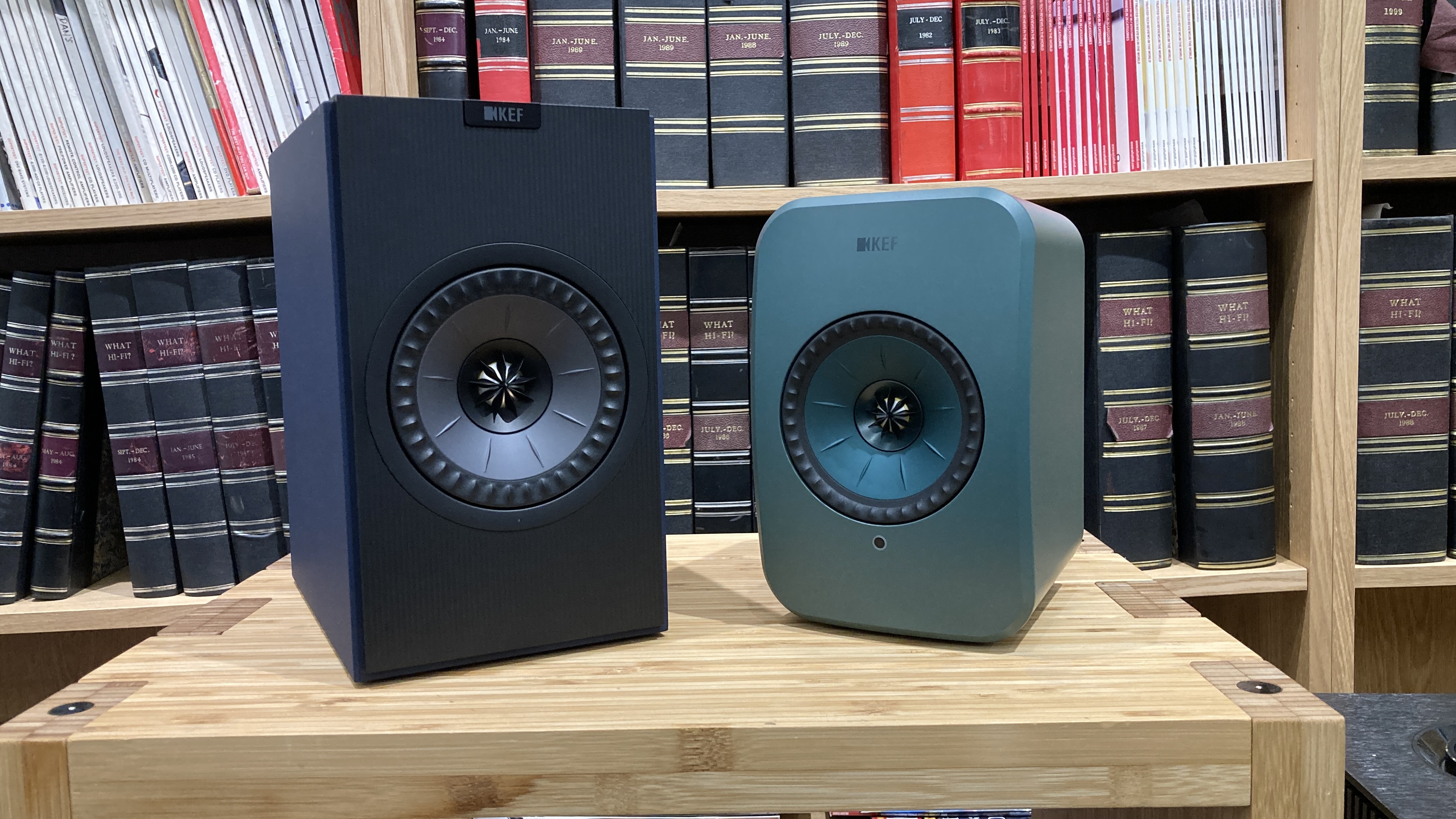 KEF Coda W speaker next to smaller KEF LSX II LT speaker on wooden rack