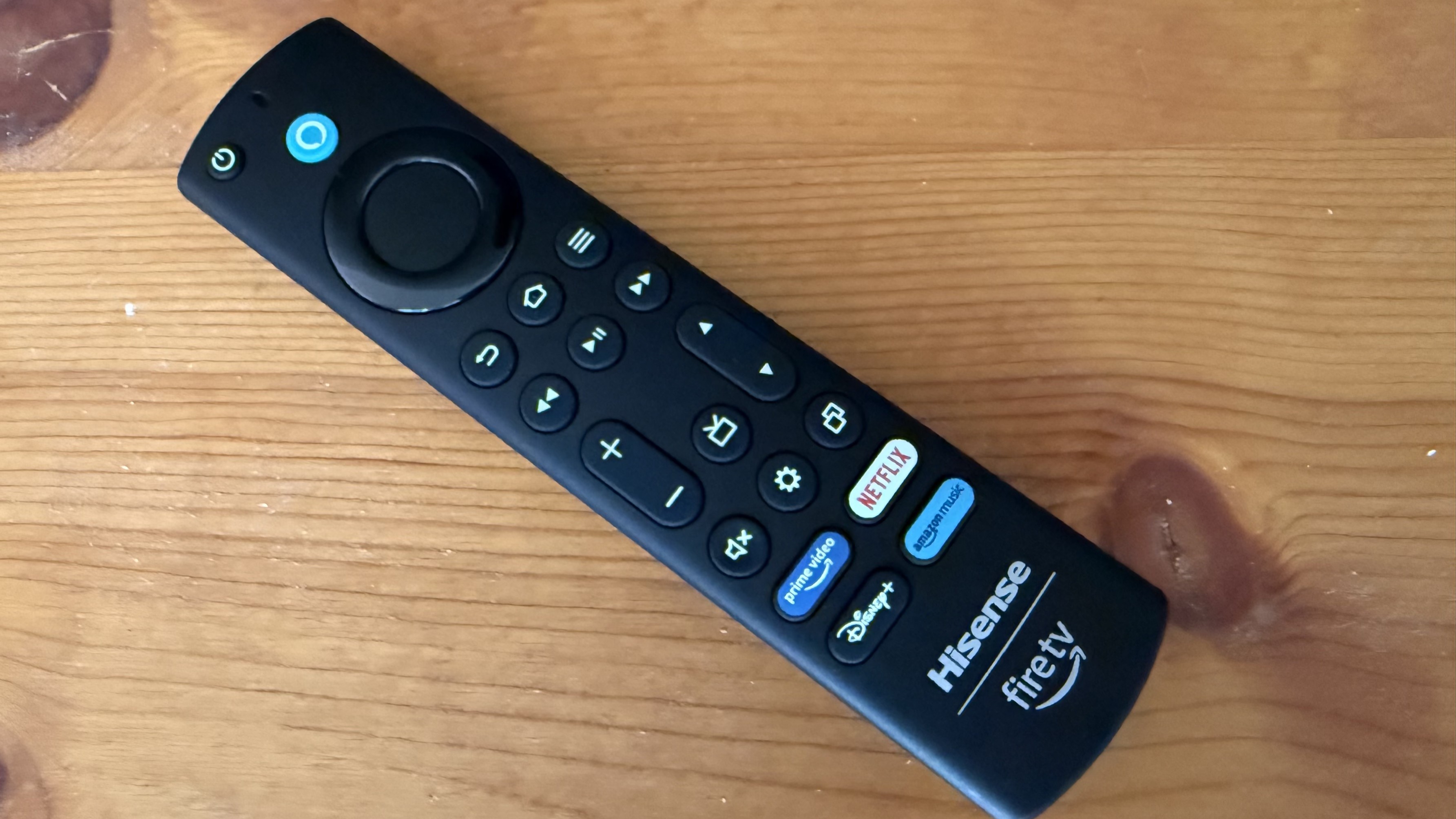 Hisense U65QF remote control on wooden surface