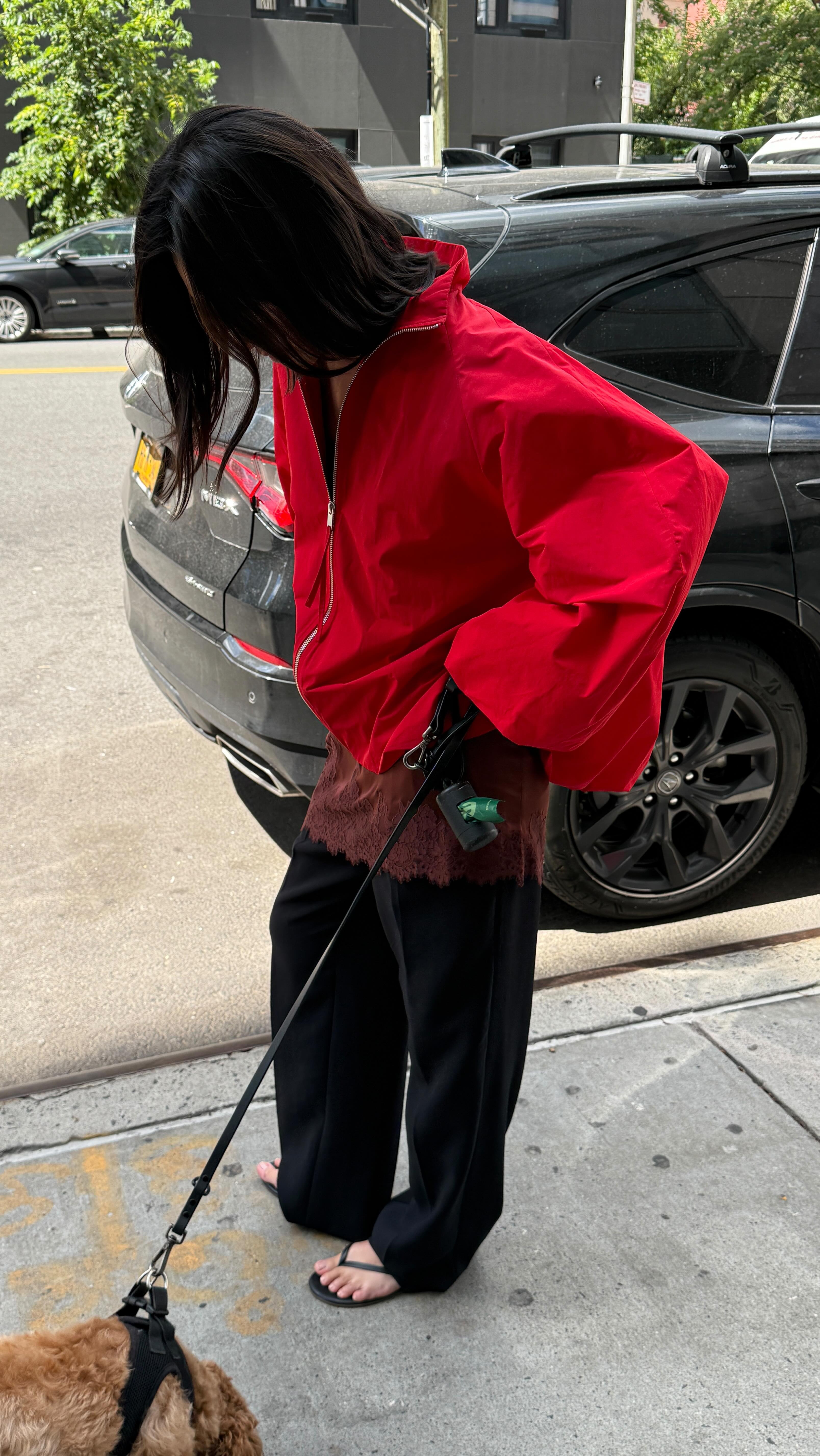 A woman wearing a red sporty jacket.