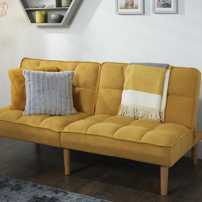 Mustard yellow sofa bed from The Range in a white living room