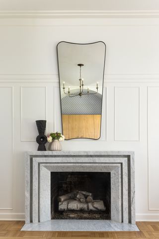 marble fireplace with white wall with molding behind