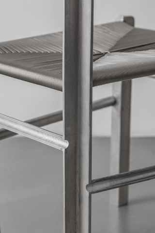 close up of a silver chair with woven seat
