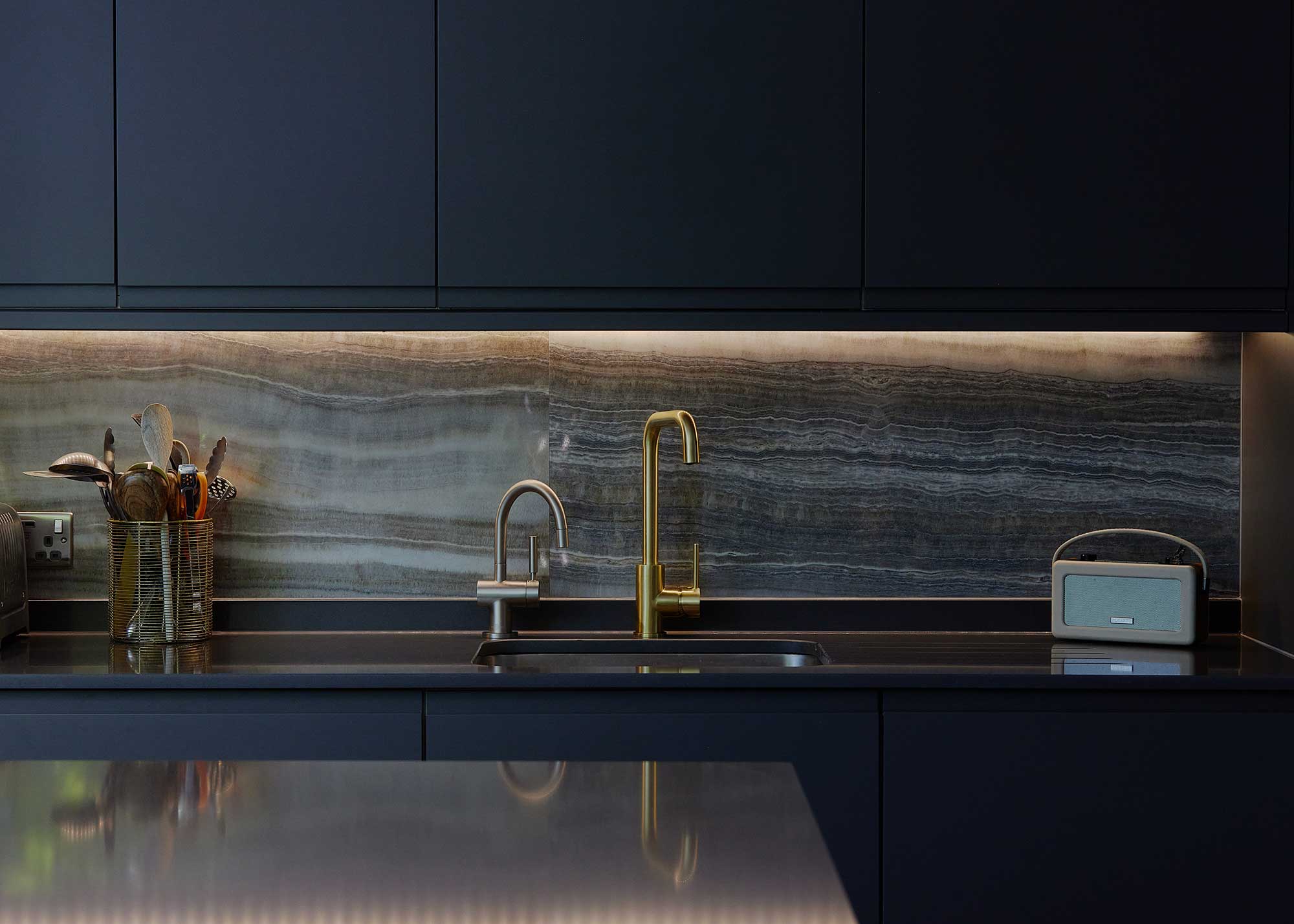 modern black kitchen cabinets with gold tap
