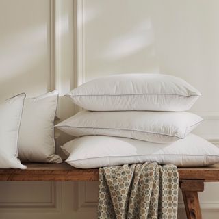 A pile of pillows on a wooden bench