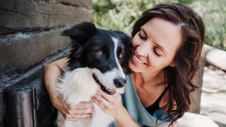 Woman hugging her dog outdoors