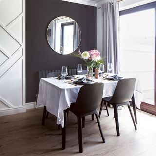 dining room with black and white panelled walls and dining table and chairs