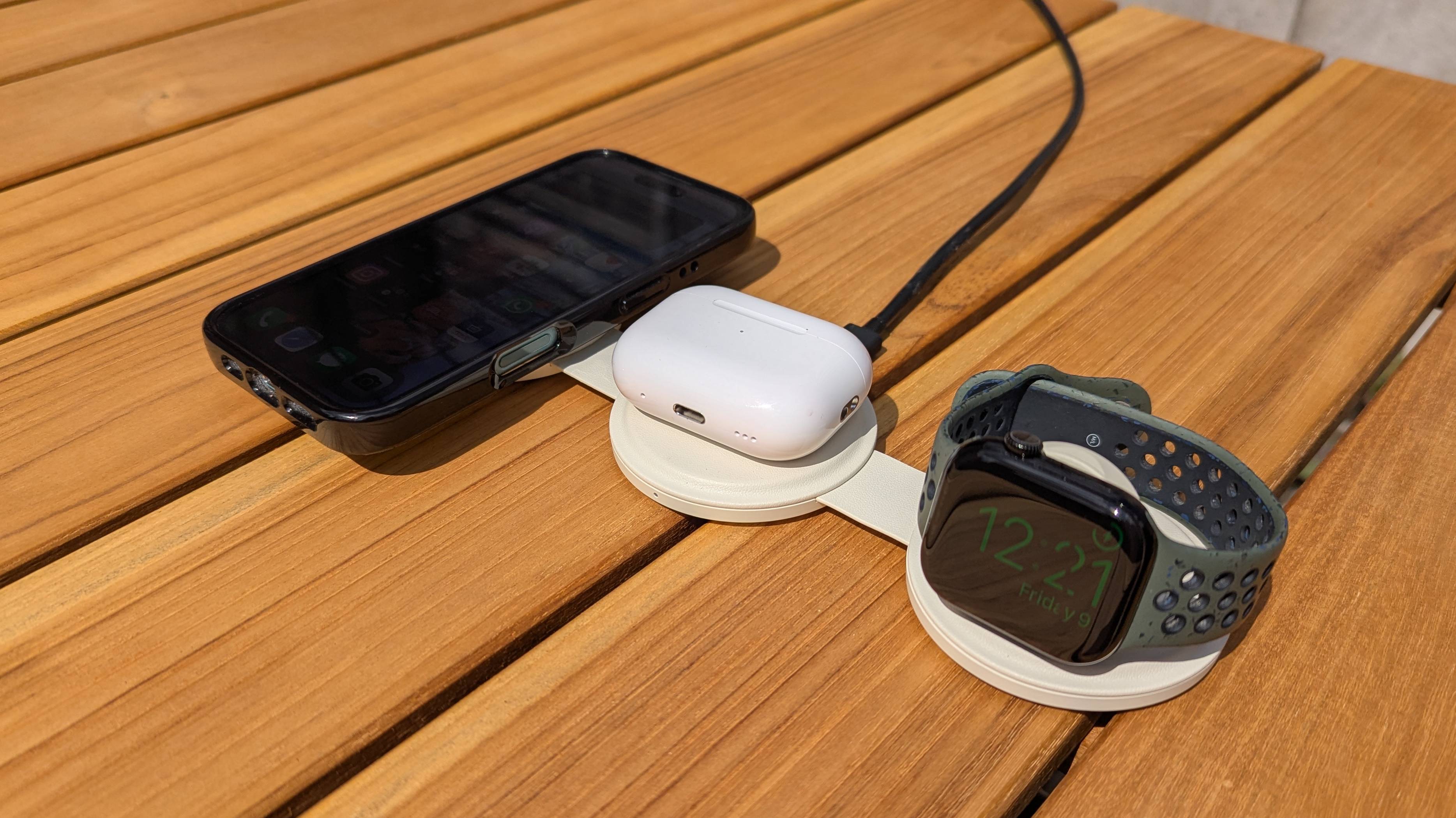 Satechi OntheGo Charger on wooden table with iPhone, Apple Watch and AirPods Pro 2 case being charged