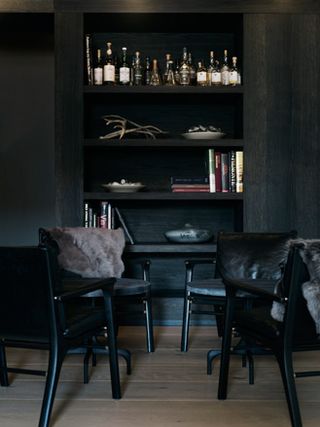 A room with bookshelf and liqour in it