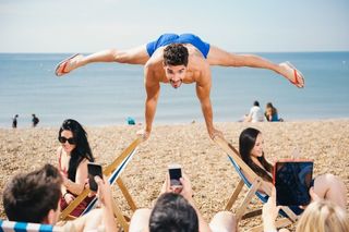 Louis Smith shows off his gymnastic skills on Brighton beach