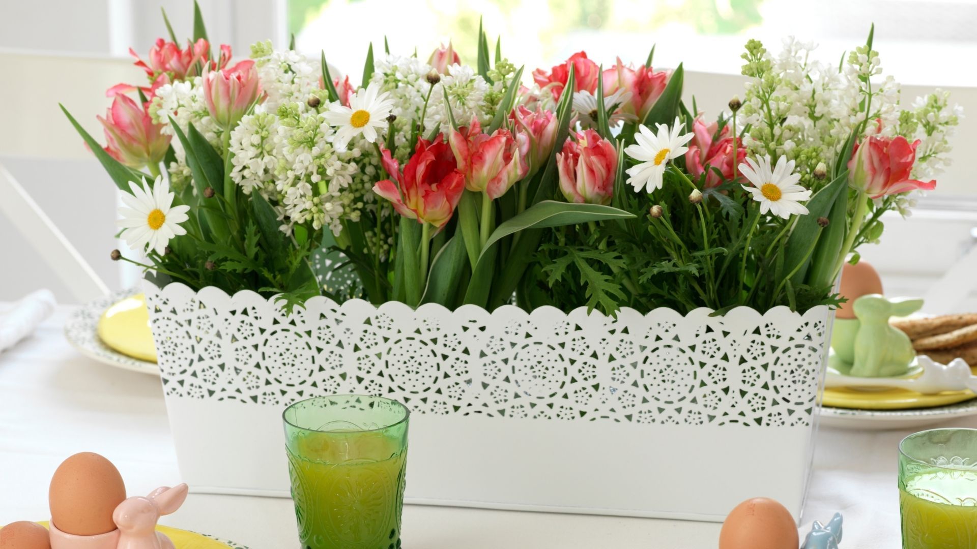 A potted plant on a table full of fresh spring flowers