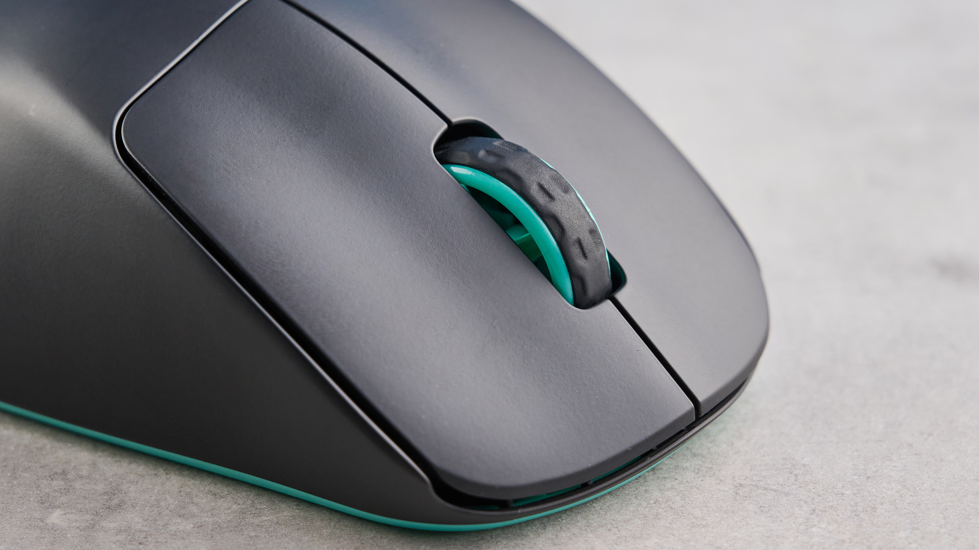 A black and teal Cherry XTRFY M64 Wireless gaming mouse