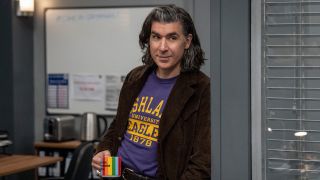 James Lance's Trent Crimm holding rainbow-styled coffee mug while standing inside Ted Lasso's office