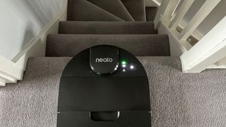 The Neato D9 at the top of a flight of stairs on carpet