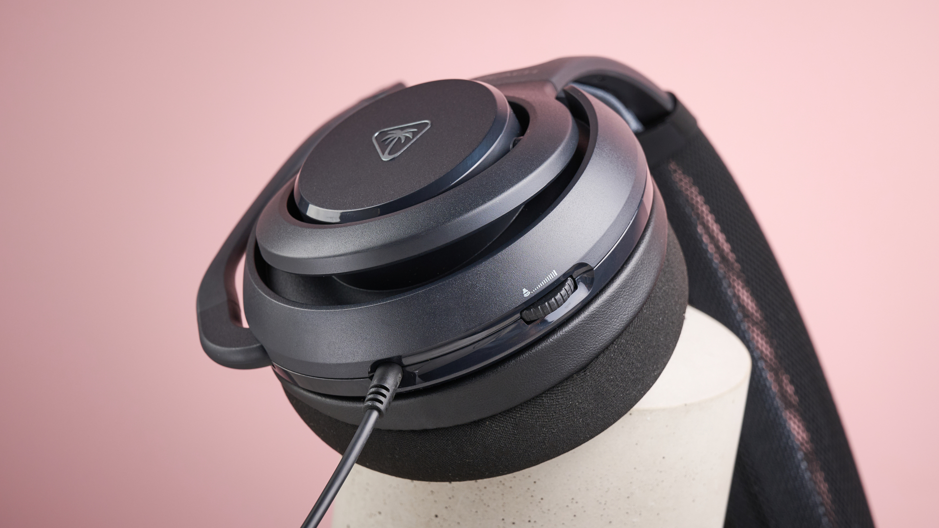 A closeup of the Turtle Beach Atlas 200&#039;s earcup, volume control dial and 3.5mm cable.