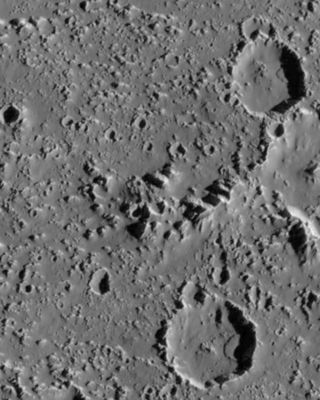 A gray image showing a heavily craters surface.