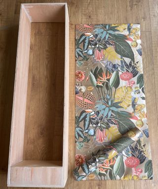 DIY bookcase under construction next to a sheet of patterned wallpaper