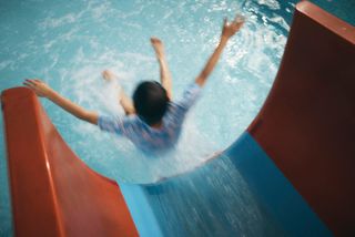 a child going down a water slide at a parkdean resort swimming pool