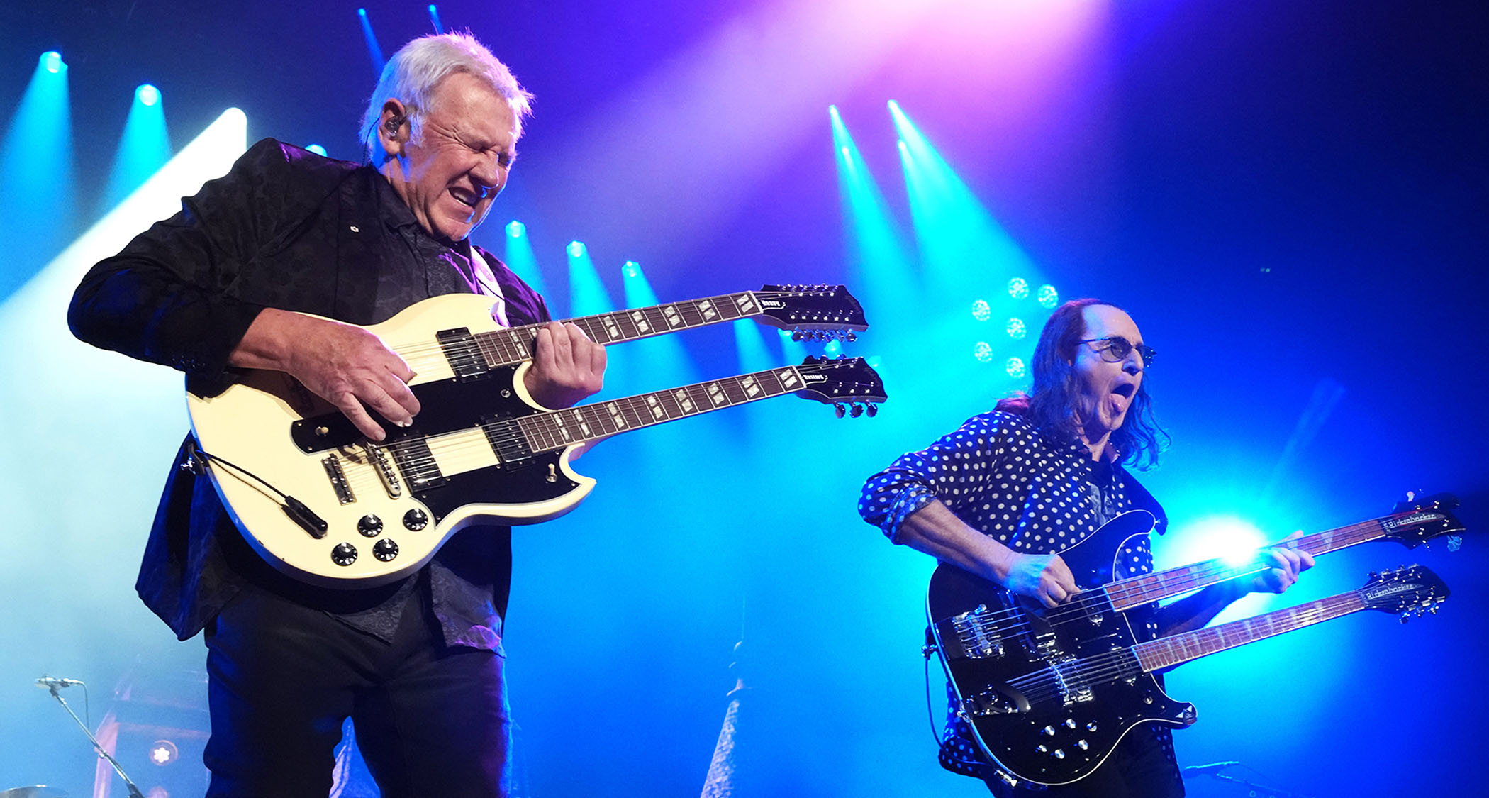 Alex Lifeson and Geddy Lee of Rush rock double-necks during a 2026 reunion show in LA.