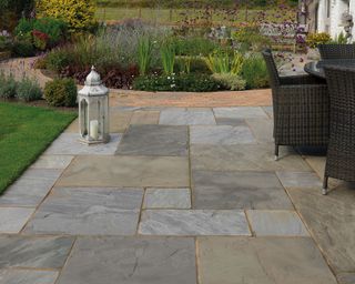 Indian sandstone paved patio and pathway leading to a circular path around a flowerbed