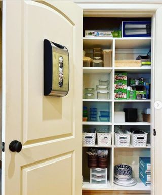 An open pantry door showing wooden shelves that have organized containers stored on them