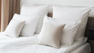 Collection of clean white pillows on bed