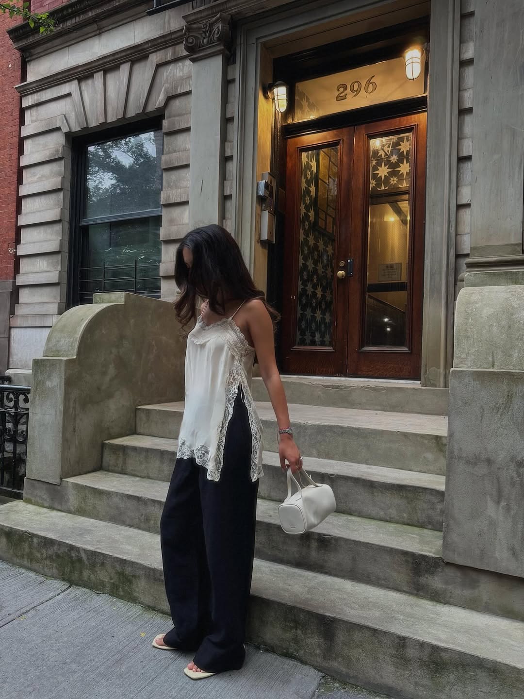 @danielasaae wearing a lace trim tank top and ivory Freja Jane handbag