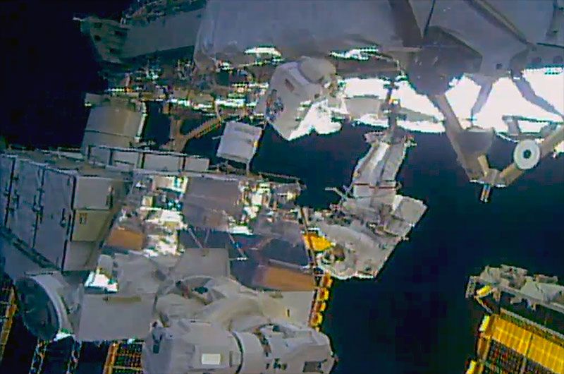 NASA astronauts Jessica Meir (foreground, in spacesuit with red stripes) and Christina Koch (with back turned to camera) work to upgrade batteries during a spacewalk outside of the International Space Station on Monday, Jan. 20, 2020. 