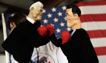 A woman holds boxing hand puppets of Newt Gingrich and Mitt Romney: The two GOP presidential frontrunners have been tearing into each other ahead of Thursday's debate in Florida.