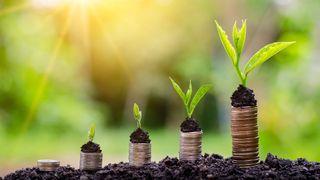 five stacks of coins standing on soil with progressively more mature seedlings on top of them, symbolising investment and growth