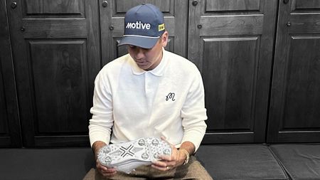 Jason Day holding a Payntr X1 Proto shoe inside a locker room