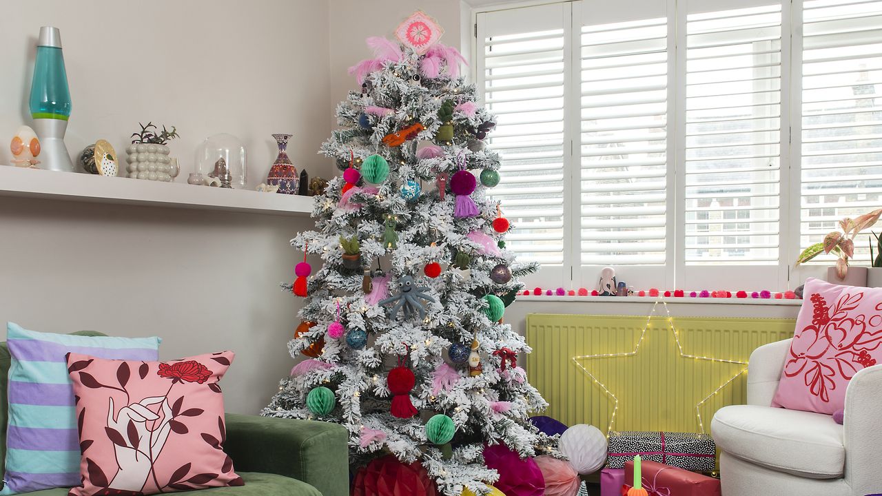 Colourful Christmas tree in living room with shutters.