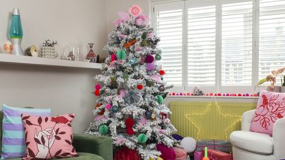 Colourful Christmas tree in living room with peacock as tree topper.