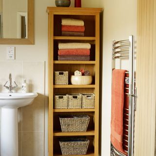 brown shelves with wicker storage and towels