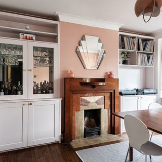 dining room with pink wall, period fireplace and Art Deco mirror