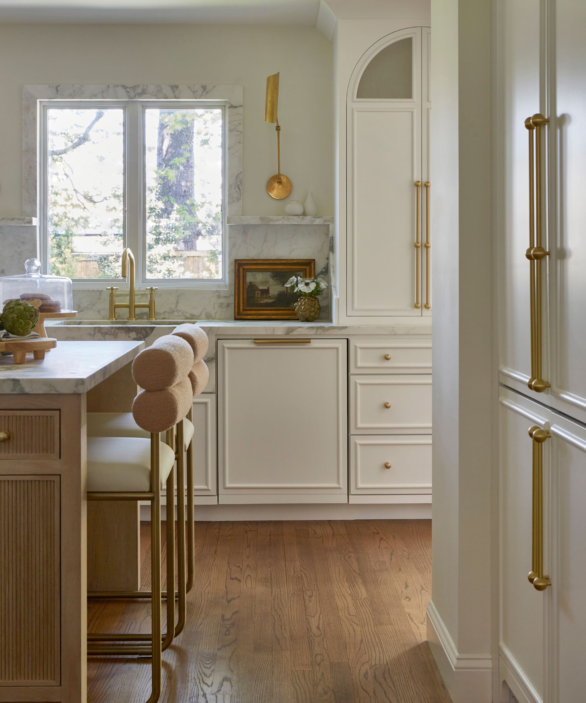 A white kitchen with a wooden island and cabinetry featuring a beaded trim detail