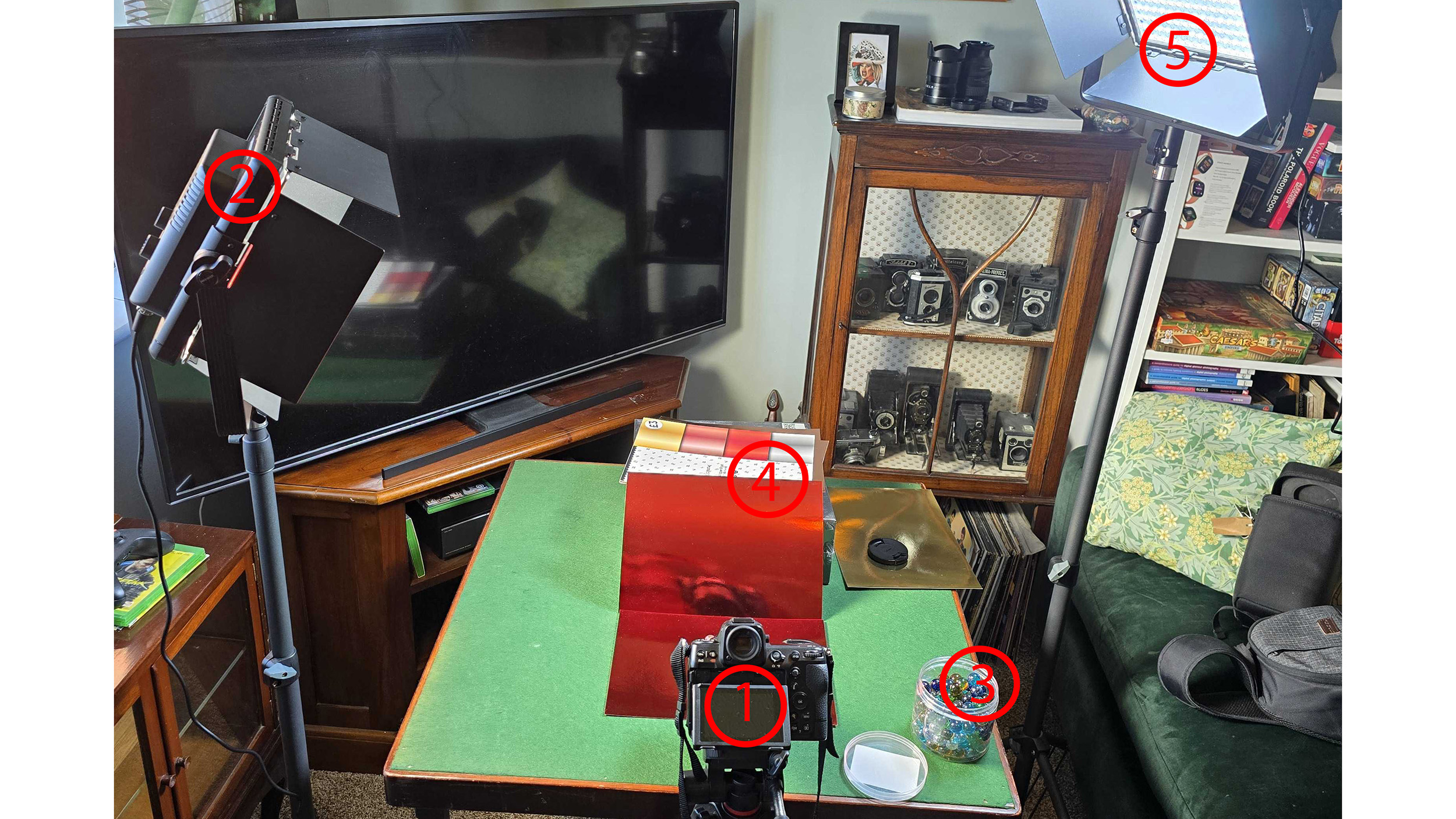 Two lights, table, camera, red card and marbles