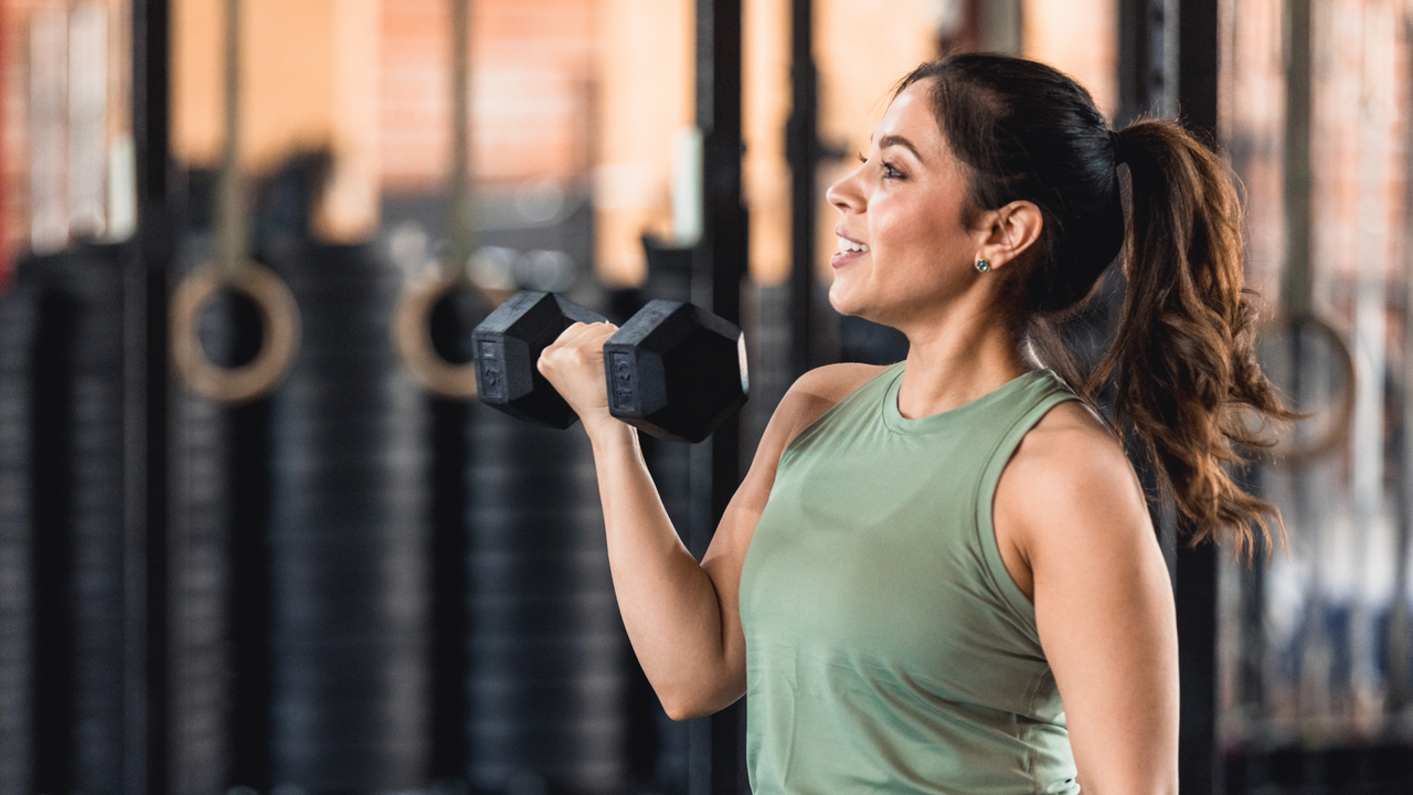 Woman doing a dumbbell curl in the gym